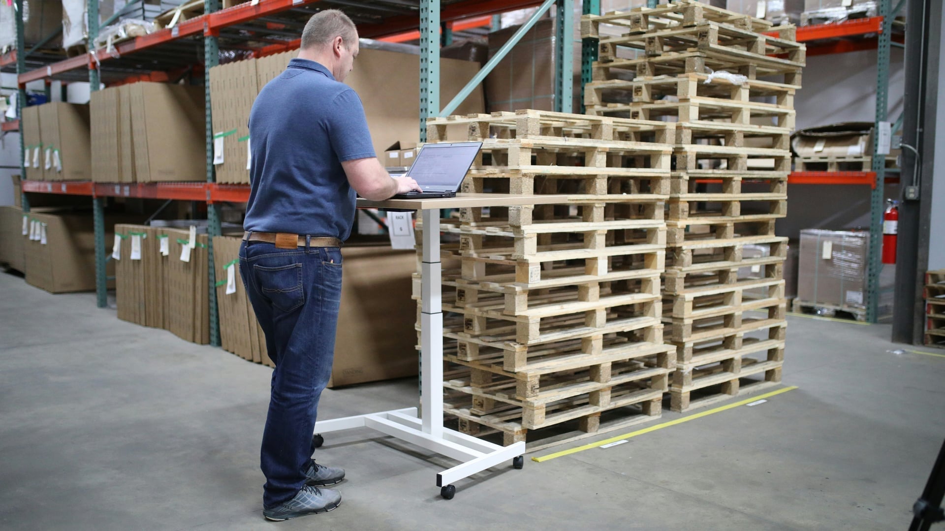 Warehouse worker drafting a quote on a laptop